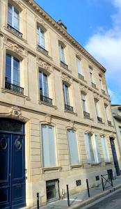 波尔多Maison Manège Bordeaux Centre的街道上一扇蓝色门的大建筑