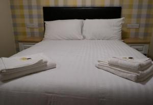 伯明翰The Aston Inn的一张白色的床,上面有两条毛巾