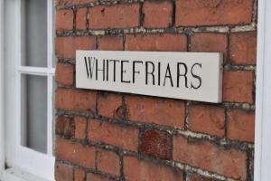 拉伊Whitefriars的砖墙上的一个标志,上面写着白恐怖字