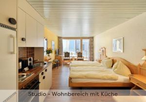 格林德尔瓦尔德Aparthotel Eiger *** - Grindelwald的一间卧室配有一张床,厨房配有水槽