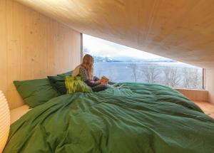 SamlanesFunkis-cabin in Herand with fantastic fjordview的坐在床上读书的女人