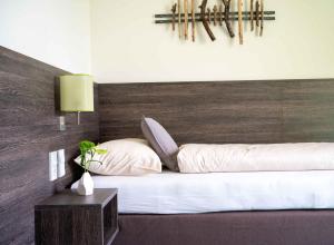 Gunskircheneee Hotel Gunskirchen的卧室配有白色的床和木制床头板