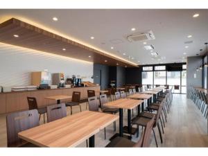 名古屋R&B Hotel Nagoya Shinkansenguchi - Vacation STAY 14999v的用餐室配有木桌和椅子