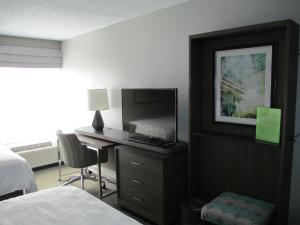 亨茨维尔亨茨维尔研究园假日酒店的一间卧室配有一张床和一张书桌及电视