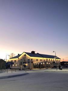 帕亚拉Hotel Lapland River的落日时停车场里的一个大型建筑