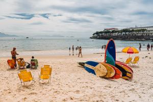 里约热内卢Selina Copacabana的沙滩上设有椅子和冲浪板