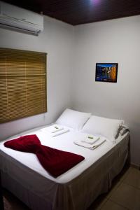 圣若热岛Pousada Raizes的卧室配有白色的床和红色毯子