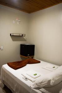 圣若热岛Pousada Raizes的一间卧室配有一张带白色床单的床和电视。