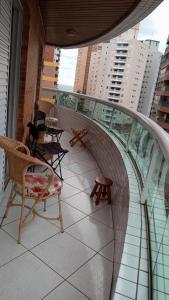 圣保罗Apartamento praia Grande的大楼内带桌椅的阳台