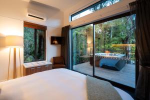 弗朗兹约瑟夫Rainforest Deluxe的卧室设有大窗户和户外浴缸。