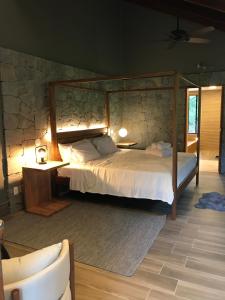维奥康德马奥Chalé Realli的一间卧室设有一张床和石墙