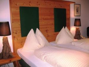 玛丽亚韦尔特豪斯伊迪丝酒店的一间卧室配有两张带白色床单和两盏灯的床。