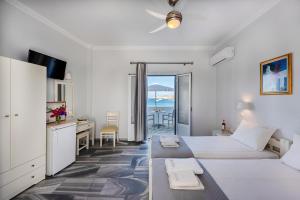 帕罗奇亚Irene Hotel - Beachfront的一间卧室设有一张床和一张书桌,享有海景