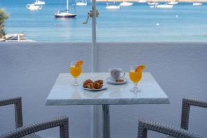 帕罗奇亚Irene Hotel - Beachfront的一张桌子,上面放着一盘食物和两杯橙汁