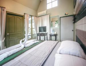 拜县拜县帕纳丽自然精品酒店的大卧室配有一张带白色床单的大床