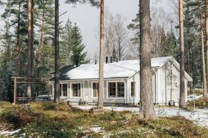 基尔科努米Katve Nature Retreat的白色的房子,树林里有一个雪盖屋顶