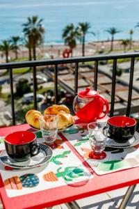 尼斯TAMARIS AP4206 By Riviera Holiday Homes的阳台上的桌子上放着杯子和盘子