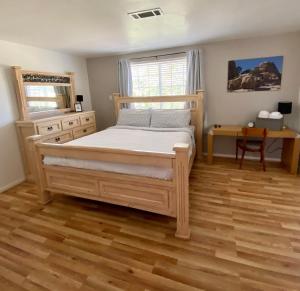 约书亚树Casa De Frank的一间卧室配有一张床,铺有木地板