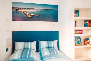 瓦尔内明德Ferienwohnung Windspiel的卧室内的一张带两个蓝色枕头的床