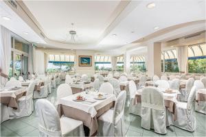比比翁贝拉维酒店的宴会厅配有白色的桌椅