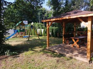 克拉科夫Hotel Zakliki的公园内带游乐场的木制凉亭