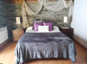 Anserall玛西亚登瓦伦蒂酒店的一间卧室配有一张带紫色枕头的大床