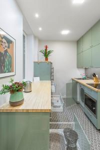 考纳斯Art & Comfort Rooms的厨房配有绿色橱柜和鲜花台面