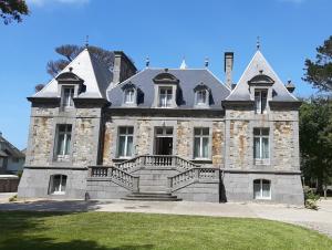 圣马洛Manoir Le Castel & Villa Beaumaris的一座古老的石头房子,前面有大楼梯