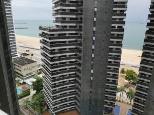 福塔莱萨Landscape Residence by Escala Imóveis的一座高大的建筑,背靠海滩