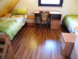 Raka切西诺瓦度假屋的配有床、书桌和四柱床的客房