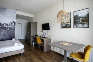 玛库姆维吉兰特海滨酒店的一间卧室配有一张床、一张桌子和一张书桌