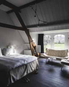 莱尔瑟姆Parc Broekhuizen l Culinair landgoed的一间卧室配有一张大床和一张沙发