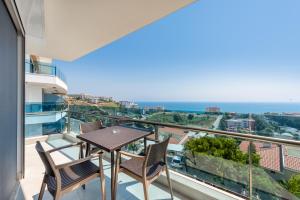阿拉尼亚Elite Luxury Suite & Spa的一个带桌椅的海景阳台