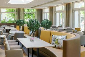 塞巴特阿尔贝克阿尔贝克奥斯酒店的餐厅设有桌椅和窗户。