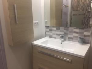 法威雷斯Chez claudine的浴室设有白色水槽和镜子