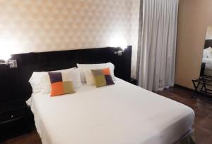 布宜诺斯艾利斯里贝拉苏尔酒店的卧室配有一张带两个枕头的大白色床