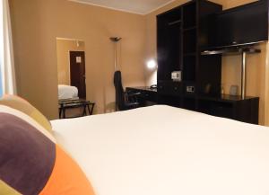 布宜诺斯艾利斯里贝拉苏尔酒店的配有一张床和一张书桌的酒店客房