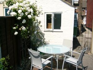 锡廷伯恩Victoria Road, comfortable 3 bedroom houses with fast Wi-Fi的庭院配有桌椅和白色鲜花。