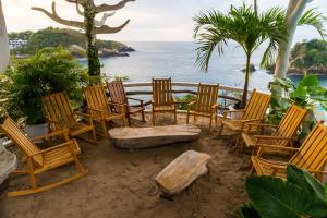 安赫尔港Hotel Pasión de Luna的海滩上摆放着一组椅子和长凳