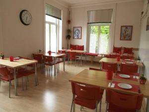 拉诺伊韦维尔加尔尼卡门别墅酒店的餐厅设有桌椅和墙上的时钟