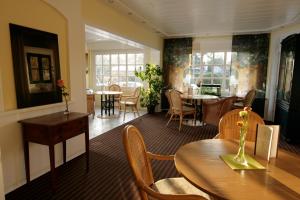 杜塞尔多夫翠园别墅酒店的用餐室设有桌椅和窗户。