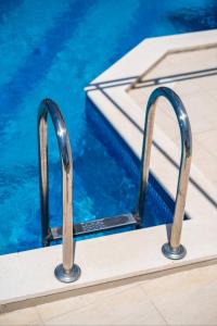 特罗吉尔米里亚娜别墅公寓的水边的游泳池,有两个金属栏杆