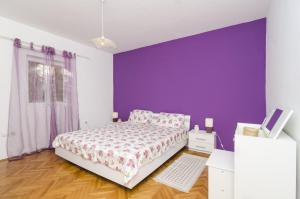 默克斯卡Holiday Home Kim的一间卧室配有一张床和紫色的墙壁