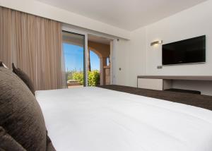 Cala MendiaInsotel Cala Mandia Resort的配有一张床和一台平面电视的酒店客房