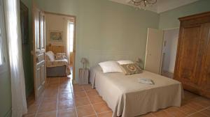 阿尔勒Au coin de la Roquette的一间带两张床的卧室,铺有瓷砖地板。