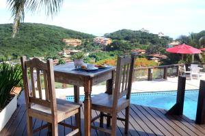 布希奥斯Ilha Branca Exclusive Hotel的池畔甲板上的木桌和椅子