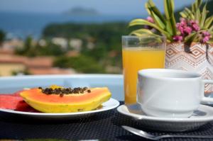 布希奥斯Ilha Branca Exclusive Hotel的一张桌子,上面放着一盘水果和一杯橙汁