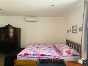 捷克卡梅尼采Summer House的一间卧室配有一张带粉红色和蓝色棉被的床