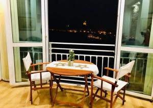 大特尔诺沃Tsarevets panoramic apartments Veliko Tarnovo的大窗户前的桌椅