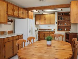 可可比奇Sea Aire Oceanfront Inn的厨房配有木桌和白色冰箱。